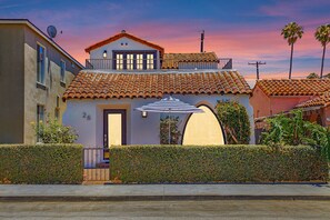 A two-story house with a tiled roof, a balcony, and a small garden. - Villa La Verne (Long Beach)