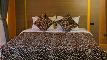 Een hotelkamer met een groot bed, een hoofdeinde met een lamp en een stoffen plafond.