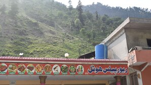 A restaurant with a signboard displaying various food items.