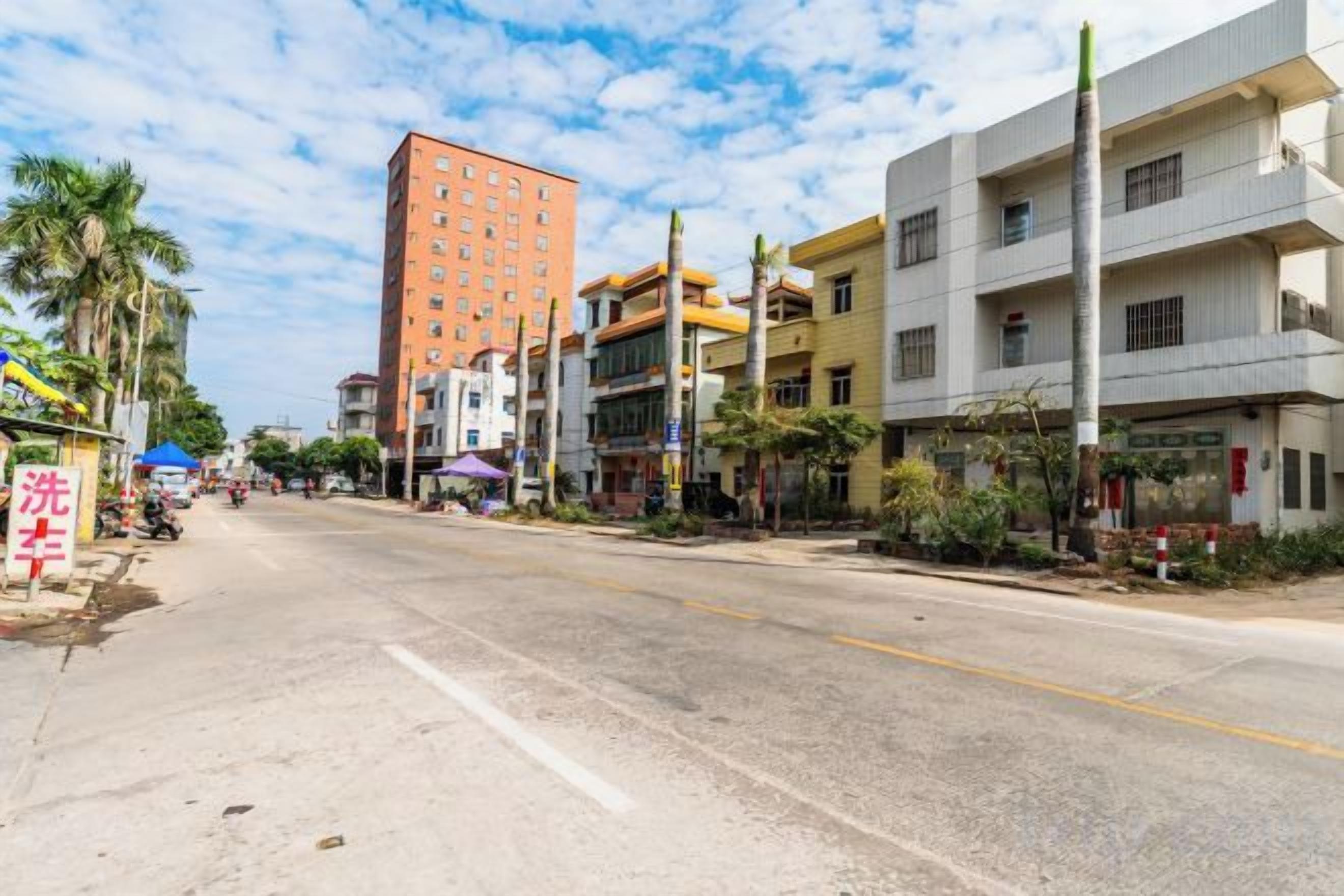 A street with buildings, a clear sky, and a road.