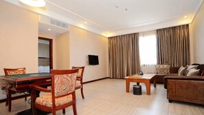 A hotel room with a pool table, a sofa, a TV, and a large window with curtains. - Liujingtai Garden Hostel (Wuchuan)