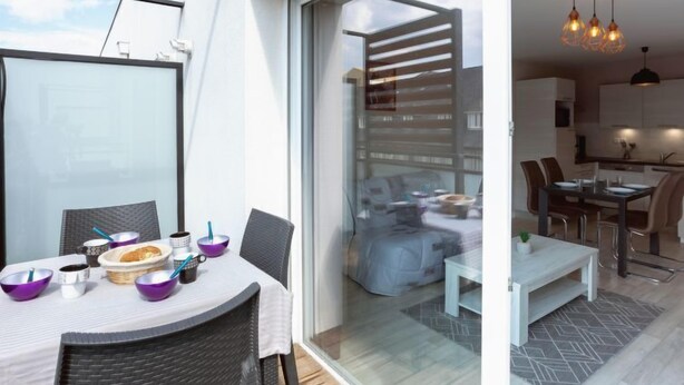 Un apartamento moderno con comedor, cocina y balcón con vistas.
