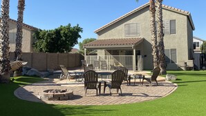 Un patio trasero con muebles de exterior y palmeras.
