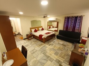 Una habitación de hotel con cama, sofá, escritorio y baño.