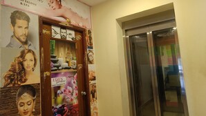 Un pasillo con una puerta de madera decorada con carteles y un espejo.