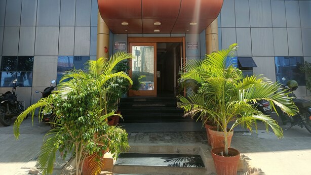 Entrada de un hotel con un letrero que anuncia GTGRANDE LUXURY ROOMS, un salón de banquetes y el logotipo de A&E Engineering Trading Company.