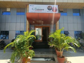 Entrada de un hotel con un letrero que anuncia GTGRANDE LUXURY ROOMS, un salón de banquetes y el logotipo de A&E Engineering Trading Company.