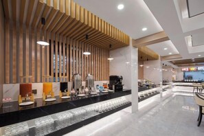 A modern hotel lobby with a long reception desk, wooden slatted ceiling, and a seating area with tables and chairs. - Xiang Wang Fu Hotel (Huaibei)