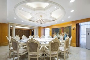 A conference room with a round table, chairs, and a chandelier. - Xiang Wang Fu Hotel (Huaibei)