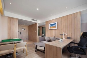 Una habitación moderna con mesa de billar, sofá, escritorio y silla.