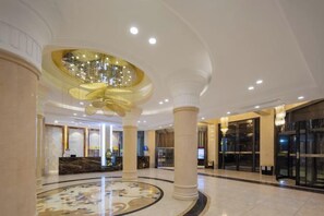 A hotel lobby with a grand chandelier, marble columns, and a reception desk. - Xiang Wang Fu Hotel (Huaibei)