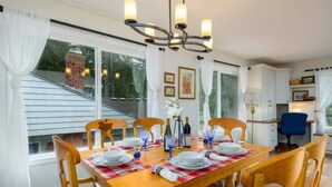 Comedor con una mesa de madera dispuesta para seis personas, rodeada de seis sillas de madera.
