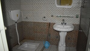 Casa de banho com sanita, bidé, lavatório e espelho.