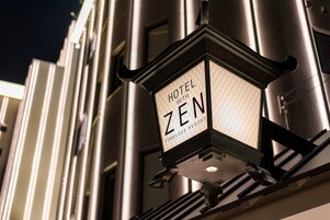 Un letrero de hotel que muestra los nombres 'HOTEL WITH ZEN' y 'TIMELESS RESORT'.