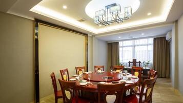 A conference room with a round table, chairs, and a modern chandelier.