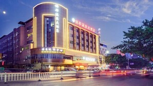 A multi-story hotel with illuminated signage and a modern architectural design. - Jinhua Hot Spring Hotel (Luchuan)