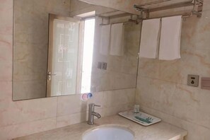 A bathroom with a sink, mirror, and towel rack.