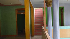 Una habitación con piso estampado, pared verde y puerta de madera.