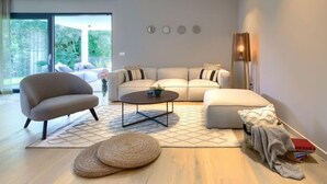A modern living room with a sofa, armchair, coffee table, and a view of the outdoors. - Villa Valle by Interhome (Rovinj/Bale)