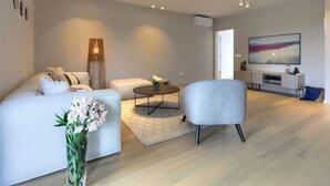 A modern living room with a sofa, armchair, coffee table, and a flat-screen TV. - Villa Valle by Interhome (Rovinj/Bale)