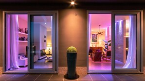 A modern interior with sliding glass doors, a potted plant, and a dining area with chairs and a table. - Villa Atmosfere 8 in Frassi (Arce)