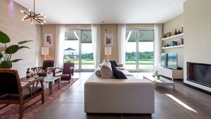 A modern living room with a sofa, TV, and dining area. - Villa Atmosfere 8 in Frassi (Arce)