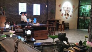 Un restaurante con una decoración rústica, que incluye mesas de madera, un piano y máscaras decorativas en la pared.