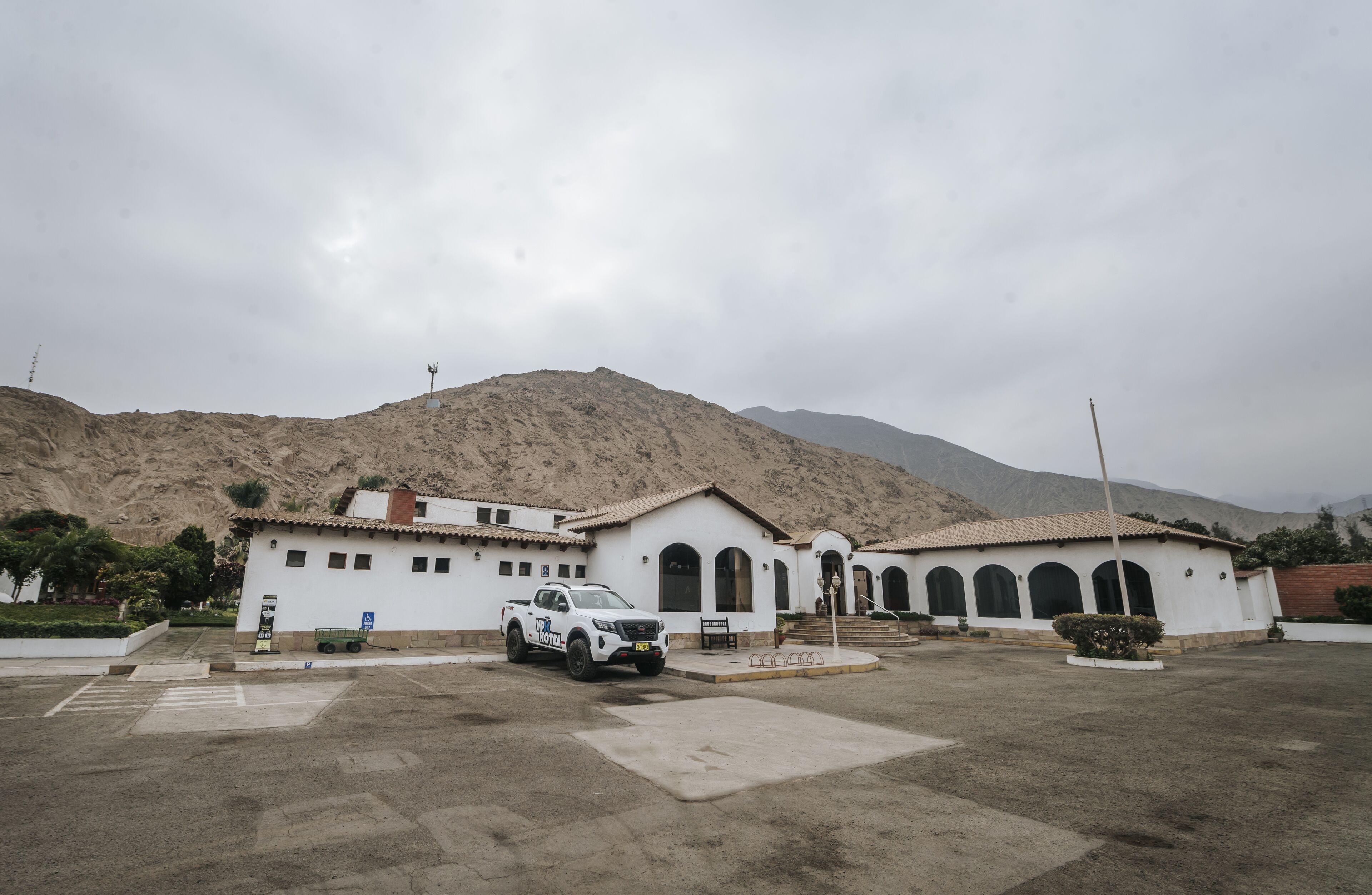 Un bâtiment blanc avec un parking et un camion.
