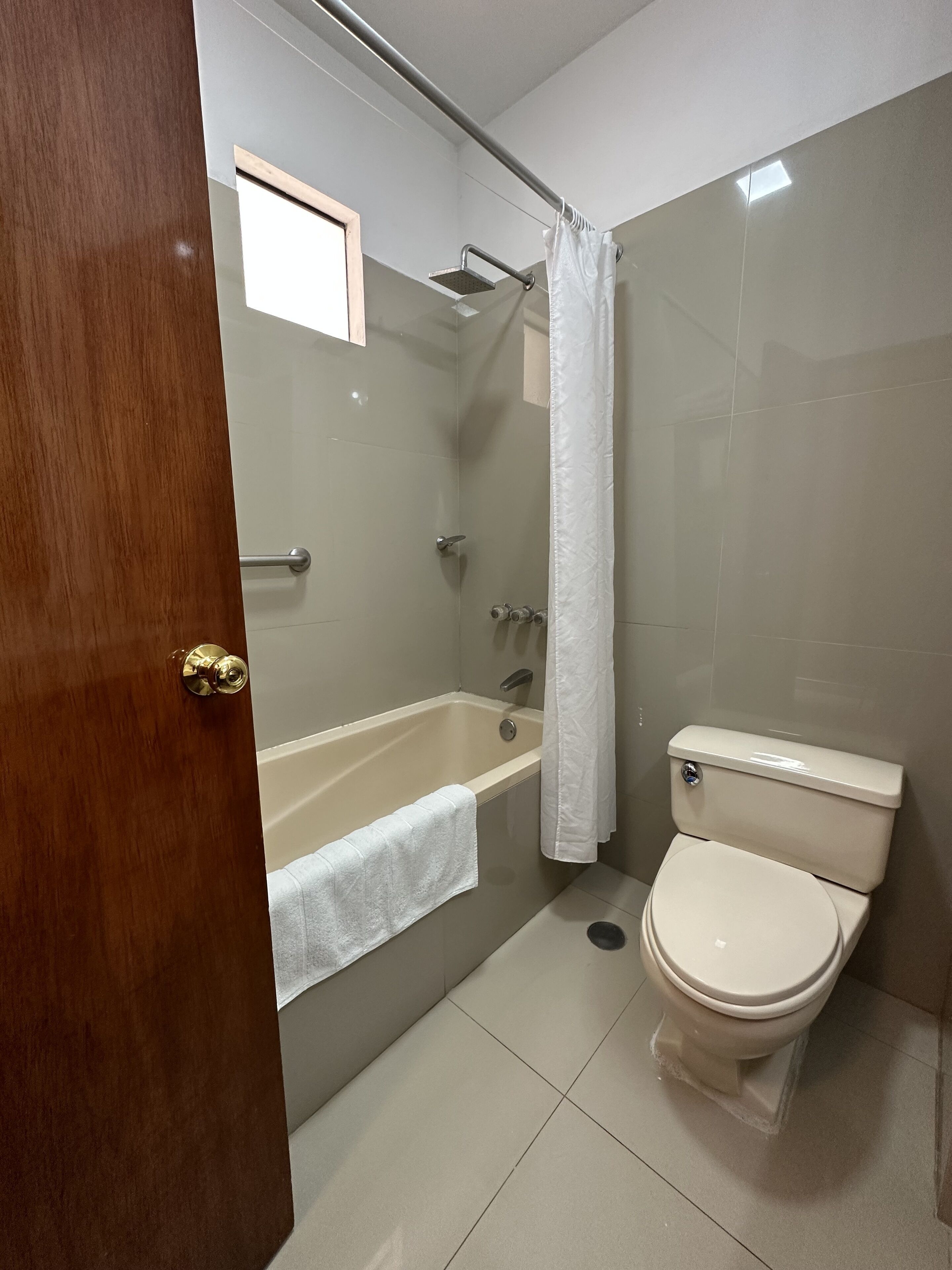 A bathroom with a bathtub, toilet, and a shower curtain.