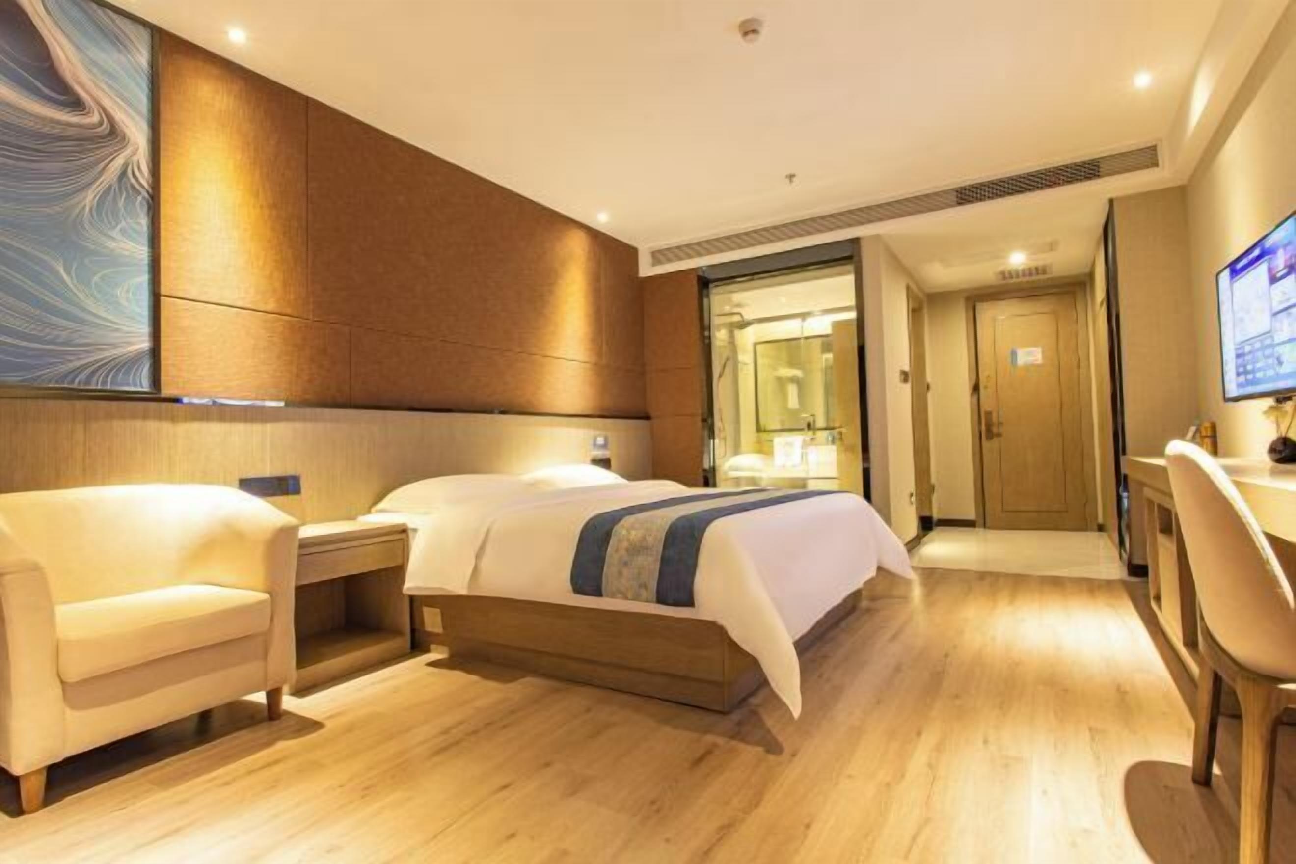 Habitació d'hotel amb un llit, escriptori, cadira i televisió.