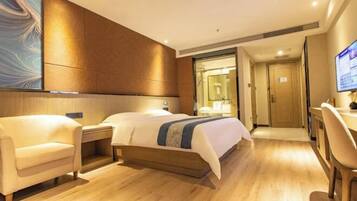 Een hotelkamer met een bed, een bureau, een stoel en een televisietoestel.