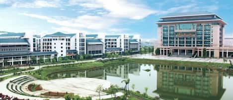 A modern building complex with a central courtyard and a reflective water feature.