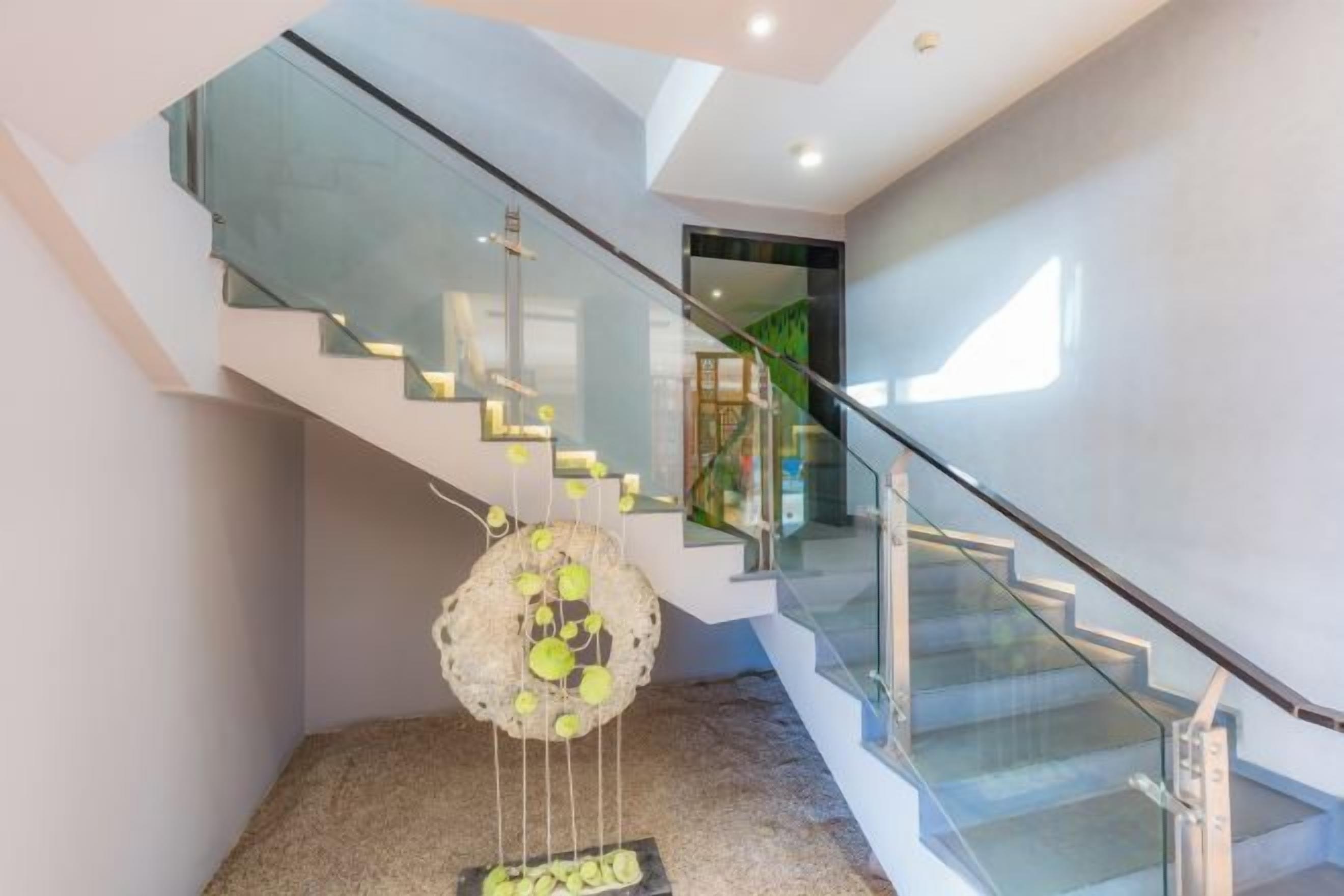 A modern staircase with glass railings and a decorative hanging sculpture.