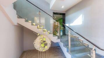 A modern staircase with glass railings and a decorative hanging sculpture.