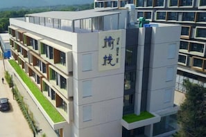 A multi-story building with a flat roof, large windows, and a green roof terrace. - The Elms lnn(Zhuhai BNBU) (Zhuhai)