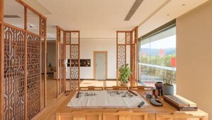 Una habitación japonesa tradicional con suelo de tatami, una mesa de madera baja y puertas correderas shoji.