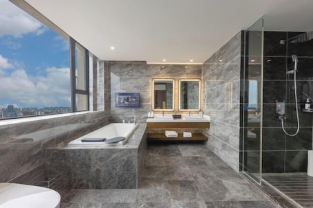 A modern bathroom with a bathtub, a shower, and a large window with a city view.. Chongqing Tongcheng Zhiguang Hotel (Tongnan Branch)