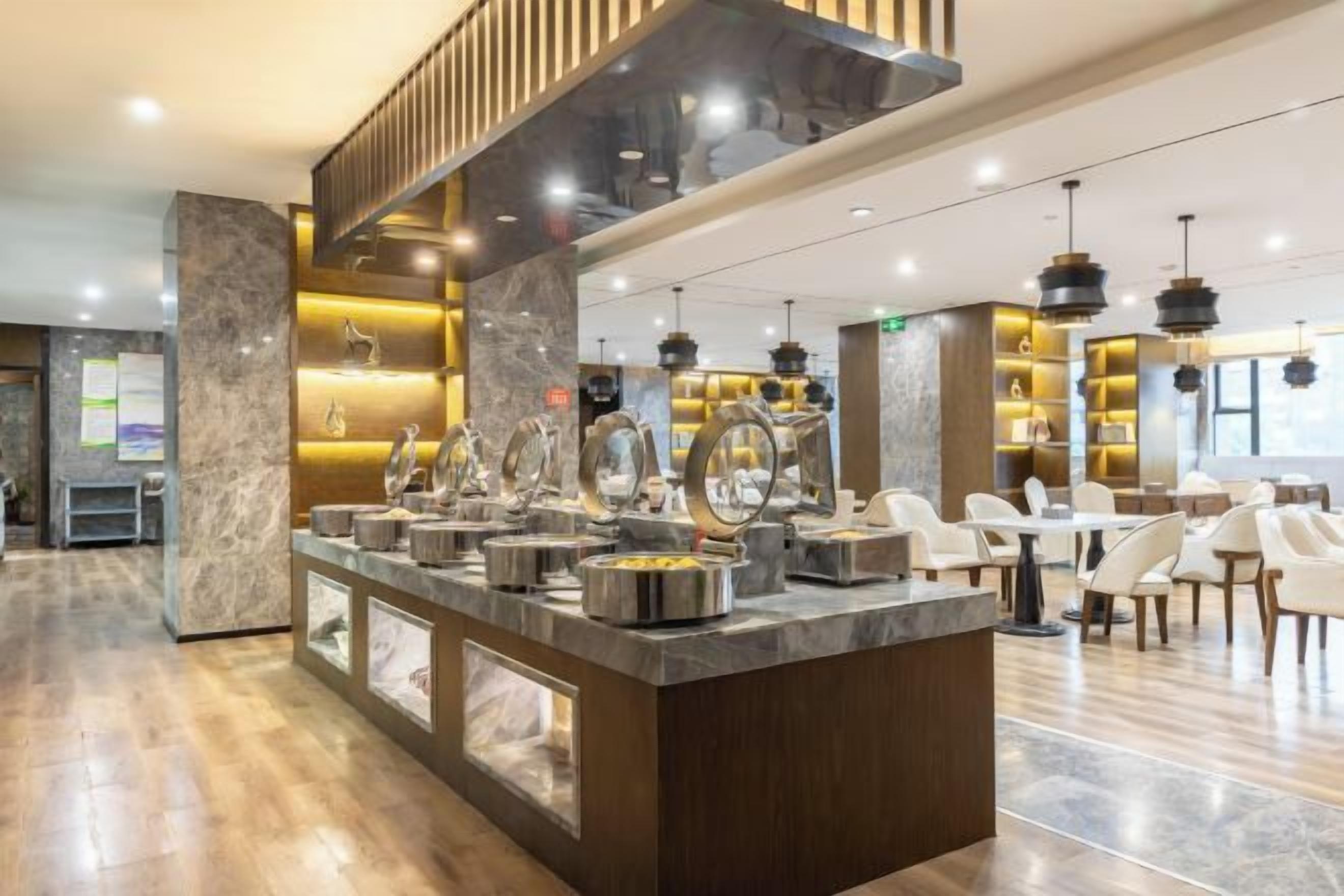 A modern hotel lobby with a marble reception desk, seating area, and contemporary lighting fixtures.