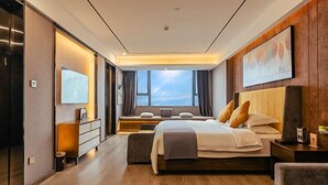 A modern hotel room with a large bed, a desk, a chair, a TV, and a window with curtains. - Chongqing Tongcheng Zhiguang Hotel (Tongnan Branch) (Chongqing)