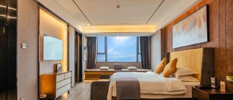 Une chambre d’hôtel moderne, dotée d’un grand lit, d’un bureau, d’une chaise, d’une télévision et d’une fenêtre avec des rideaux.