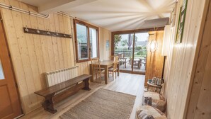A wooden interior with a bench, chairs, a table, and a rug. - Chalet Ouréa (Campan)
