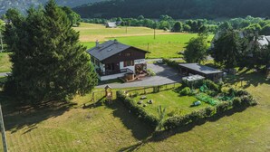 A house with a large porch, a swing set, and a fenced yard. - Chalet Ouréa (Campan)
