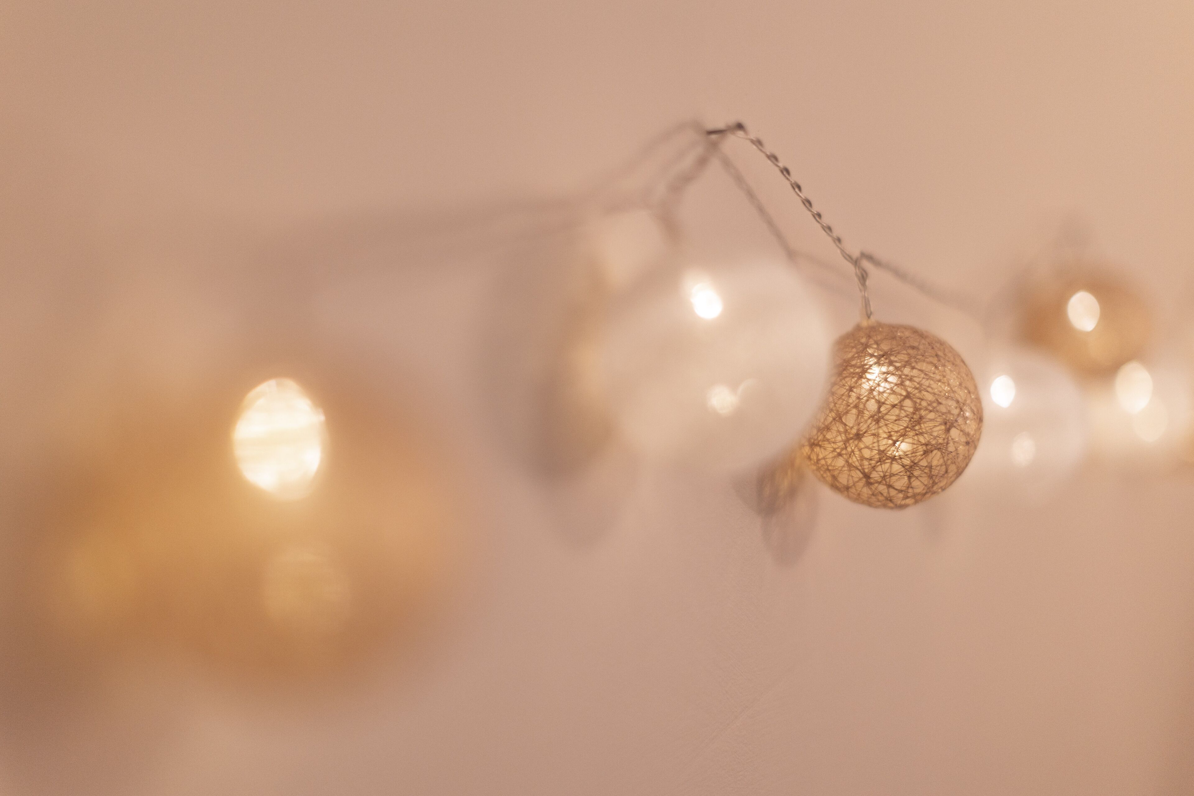 Uma luminária decorativa com design esférico, pendurada por um fio.