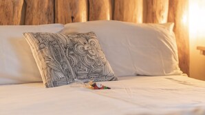 A bed with a white headboard and a patterned pillow. - Chalet Ouréa (Campan)