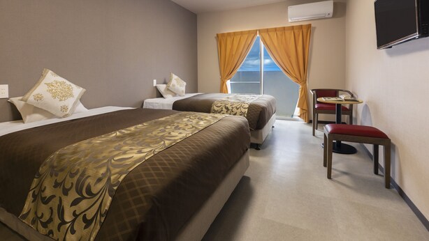 A hotel room with two beds, a desk, and a chair. - Mr.KINJO Miyakojima Aparagi Resort 1 (Miyakojima)