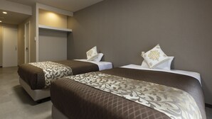 A hotel room with two beds, each with a patterned bedspread and matching pillows. - Mr.KINJO Miyakojima Aparagi Resort 1 (Miyakojima)