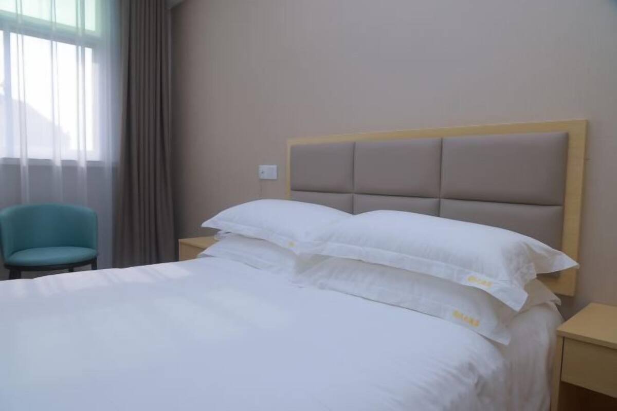 Ein Hotelzimmer mit Bett, Sessel und Nachttisch.