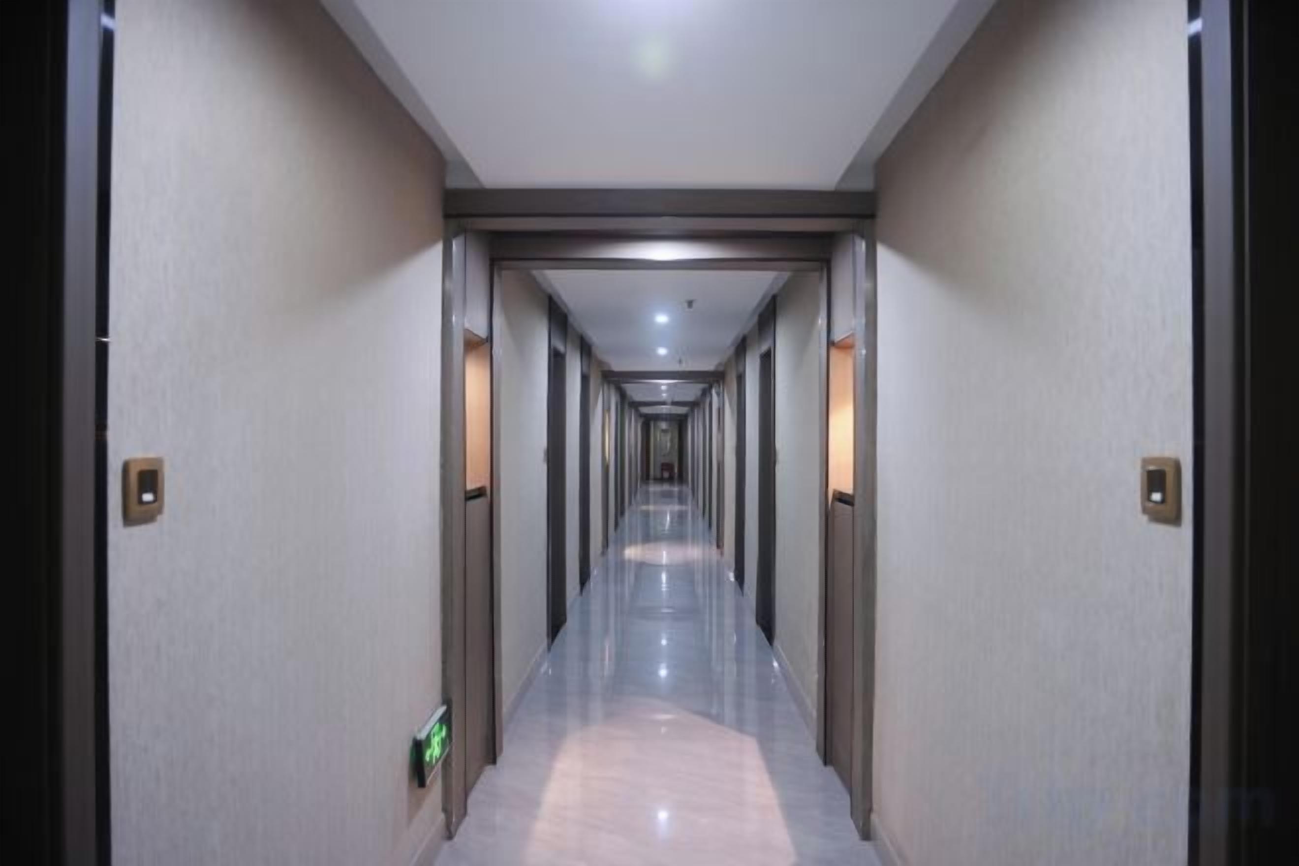 Um corredor comprido e estreito, com portas em ambos os lados, que dá acesso a vários quartos.