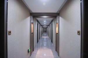 Un largo pasillo estrecho con puertas a ambos lados, que conduce a habitaciones.