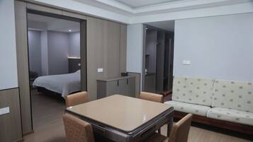 A hotel room with a bed, a table, chairs, a sofa, and a wardrobe.